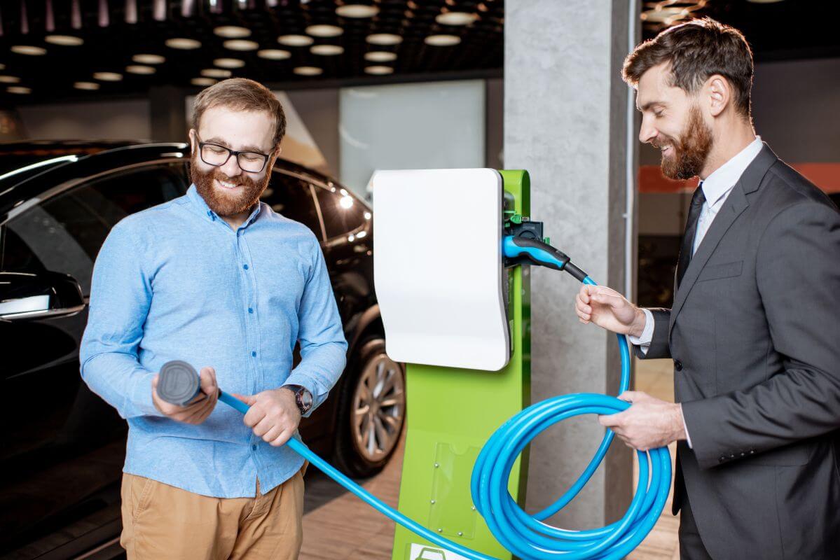 Dwóch mężczyzn uczestniczy w montażu stacji ładowania samochodów elektrycznych.