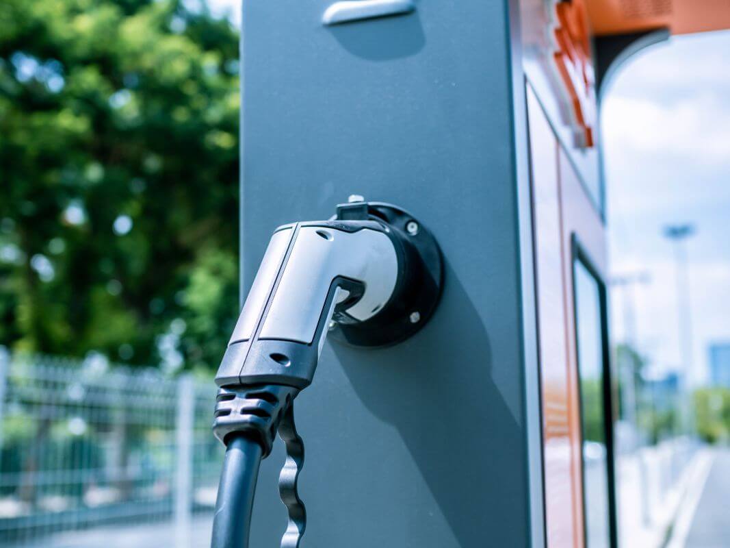 Instalacja stacji ładowania samochodów elektrycznych ukazana z perspektywy zbliżenia na wtyczkę.